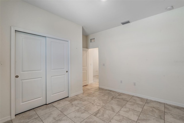 1443 SW 1st St, Cape Coral, FL 33991 - unfurnished bedroom with a closet, baseboards, and light tile patterned floors