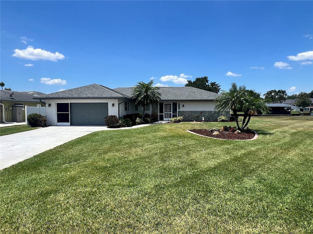 ranch-style home featuring stucco siding, an attached garage, a front lawn, and driveway