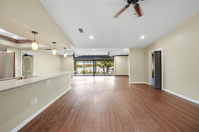 376 Portofino Dr, Punta Gorda, FL 33950 - unfurnished living room featuring a ceiling fan, baseboards, a sink, wood finished floors, and recessed lighting