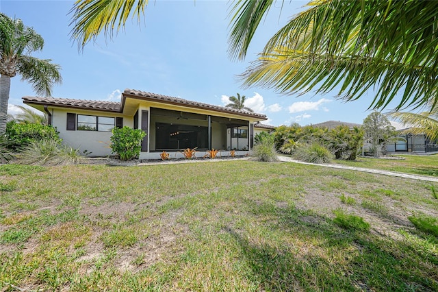 376 Portofino Dr, Punta Gorda, FL 33950 - rear view of house with a sunroom, a tile roof, a lawn, and stucco siding