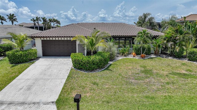 376 Portofino Dr, Punta Gorda, FL 33950 - mediterranean / spanish-style home with a tile roof, an attached garage, driveway, a front lawn, and stucco siding
