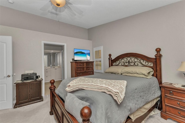 bedroom with connected bathroom, ceiling fan, and light colored carpet