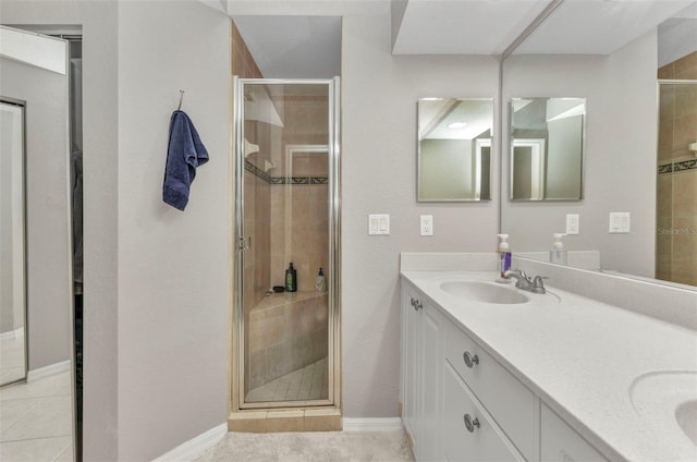 bathroom featuring a sink, double vanity, a stall shower, and tile patterned flooring