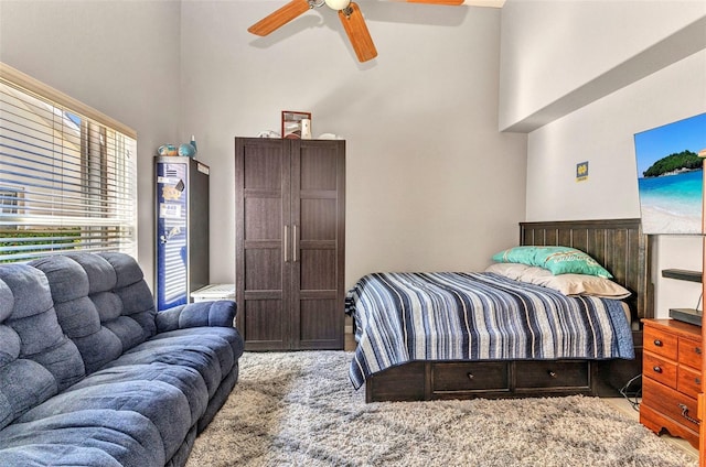 bedroom with ceiling fan and a towering ceiling