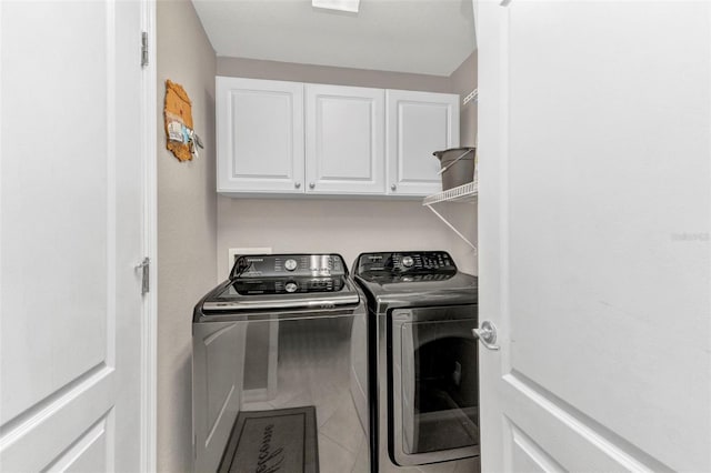 washroom with tile patterned flooring, independent washer and dryer, and cabinet space