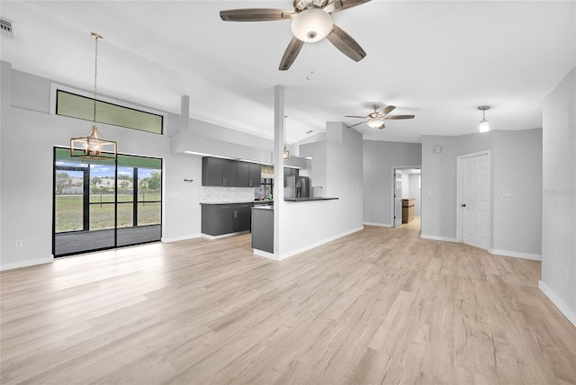 unfurnished living room featuring a ceiling fan, lofted ceiling, light wood-type flooring, a chandelier, and baseboards