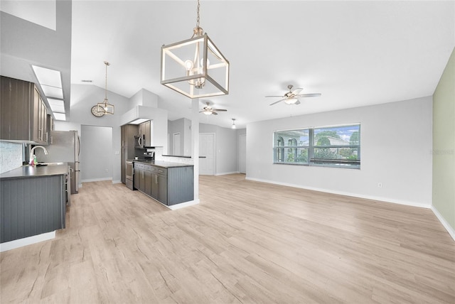 kitchen with ceiling fan, a chandelier, a sink, open floor plan, and lofted ceiling