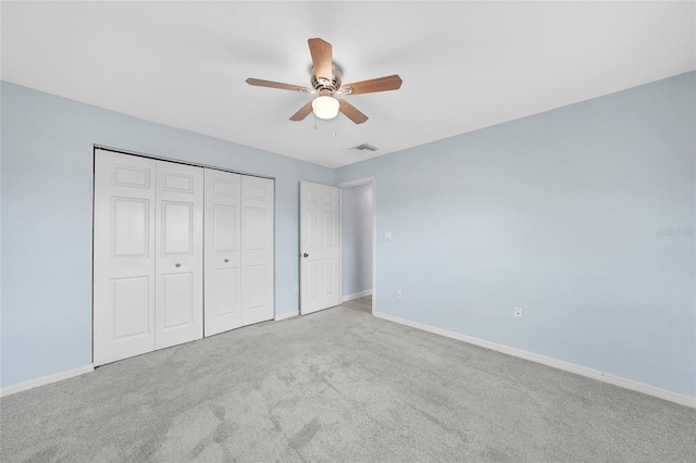 unfurnished bedroom with baseboards, carpet floors, a closet, and a ceiling fan