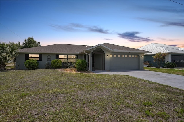 single story home featuring an attached garage, stucco siding, a lawn, and driveway