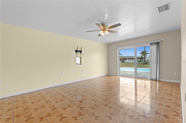 5527 Fairway Dr S, Punta Gorda, FL 33982 - unfurnished room with a ceiling fan, light tile patterned floors, baseboards, and a textured ceiling