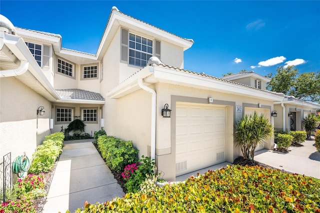 3412 Grand Vista Ct Unit 202, Port Charlotte, FL 33953 - view of front of home with stucco siding, a garage, and a tiled roof