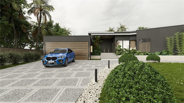 modern home with driveway, an attached garage, and stucco siding