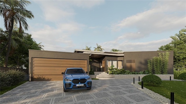 modern home with stucco siding, a garage, and driveway