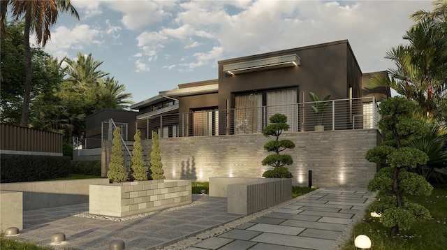 rear view of property featuring stucco siding