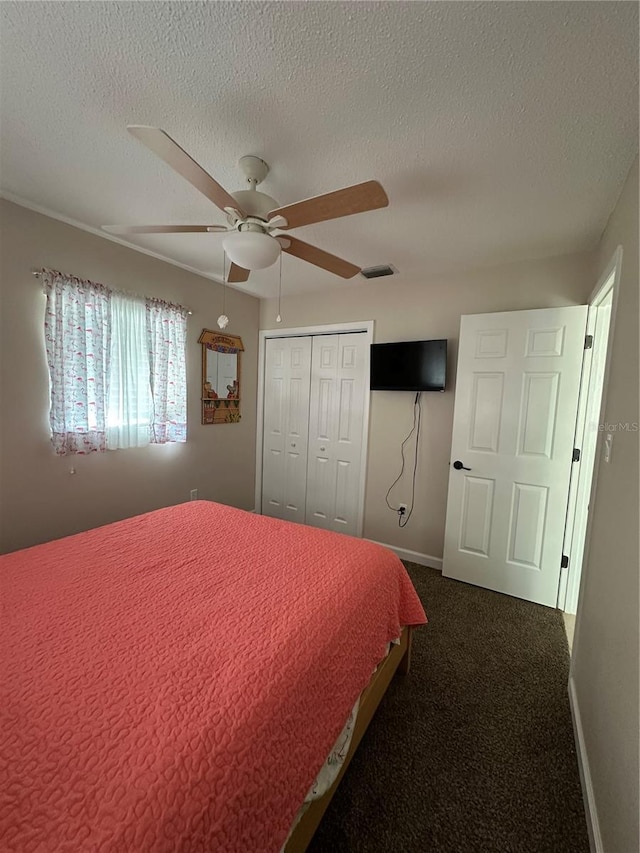 bedroom featuring a textured ceiling, a closet, a ceiling fan, and dark carpet