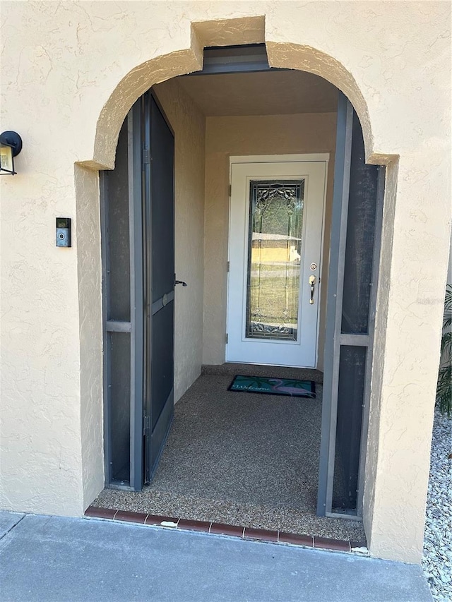 property entrance with stucco siding