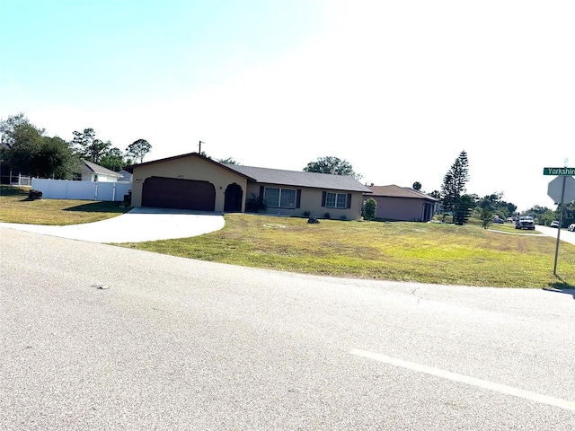 single story home with concrete driveway, a garage, a front lawn, and fence