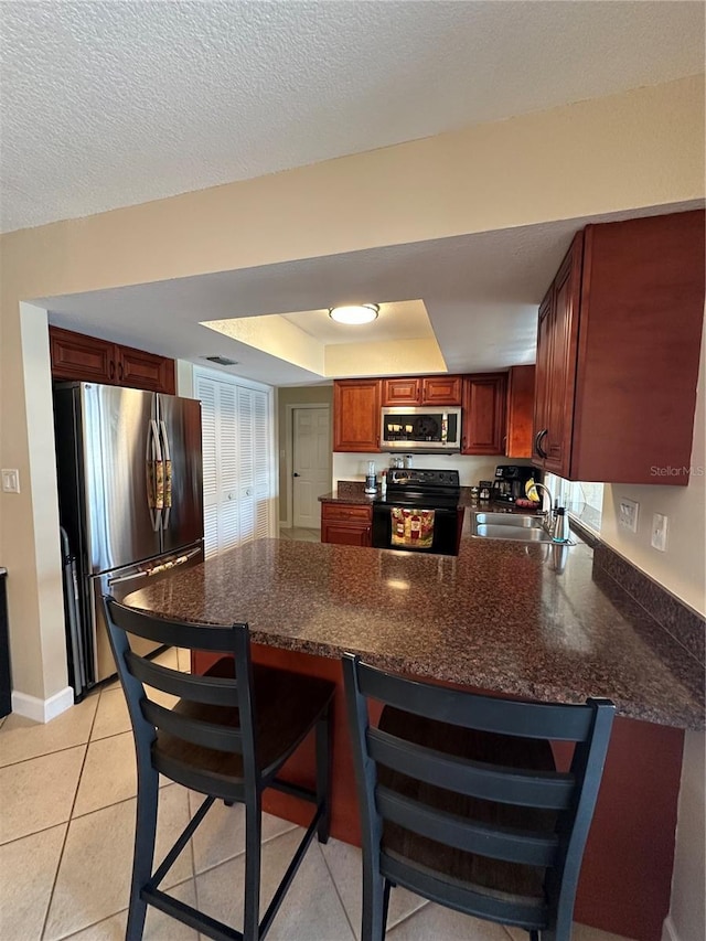 kitchen with a peninsula, a breakfast bar area, stainless steel appliances, and a sink