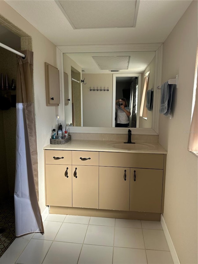 bathroom with vanity, a shower with curtain, baseboards, and tile patterned floors