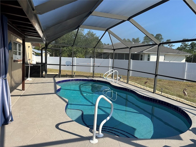 view of swimming pool featuring a patio, a fenced in pool, a fenced backyard, and glass enclosure