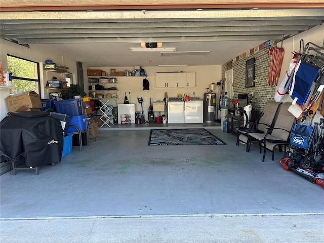 garage featuring electric water heater and independent washer and dryer
