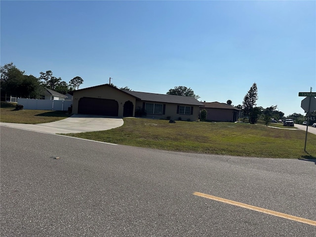 ranch-style house with concrete driveway, a front lawn, and an attached garage