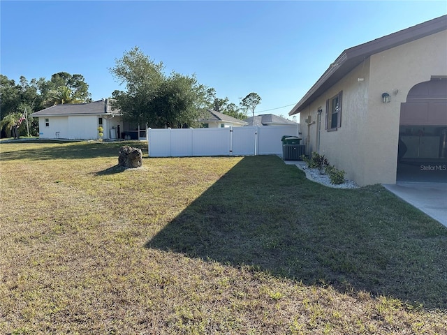 view of yard featuring central AC unit, a gate, and fence