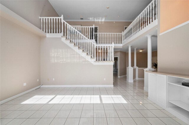 3800 Bal Harbor Blvd Unit 415, Punta Gorda, FL 33950 - entrance foyer featuring ornate columns, light tile patterned flooring, crown molding, a high ceiling, and stairway