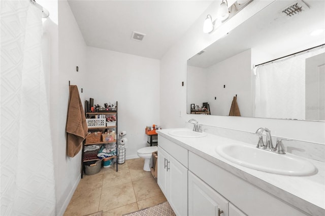 bathroom featuring a sink, toilet, baseboards, and visible vents