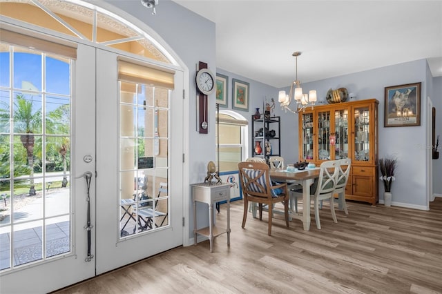 2911 Riverside Dr, Punta Gorda, FL 33950 - dining space featuring french doors, a chandelier, light wood-type flooring, and baseboards