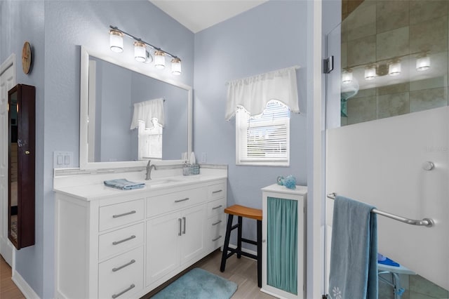 2911 Riverside Dr, Punta Gorda, FL 33950 - bathroom with tiled shower, wood finished floors, and vanity