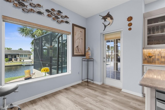 2911 Riverside Dr, Punta Gorda, FL 33950 - dining room featuring wood finished floors, a water view, and baseboards