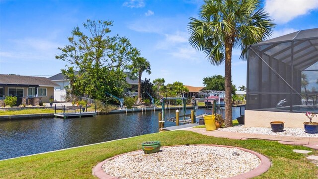 2911 Riverside Dr, Punta Gorda, FL 33950 - dock featuring boat lift, a water view, a lanai, and a lawn