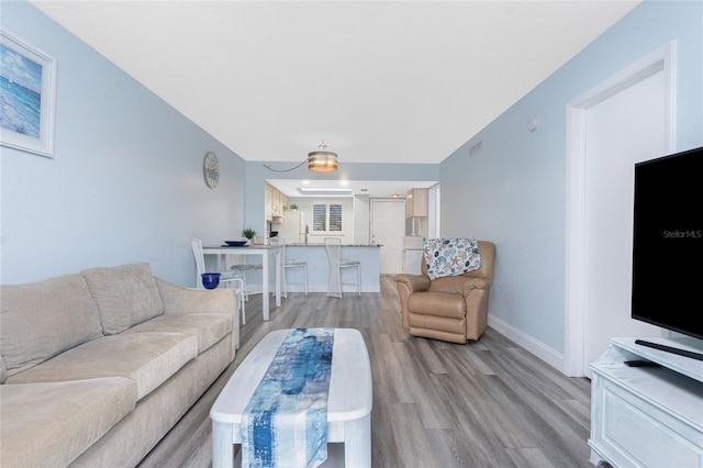 living room featuring baseboards and light wood-type flooring