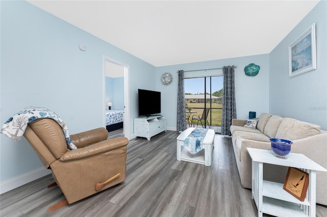 living area featuring baseboards and wood finished floors