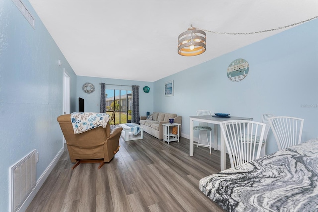 interior space with baseboards, visible vents, and wood finished floors