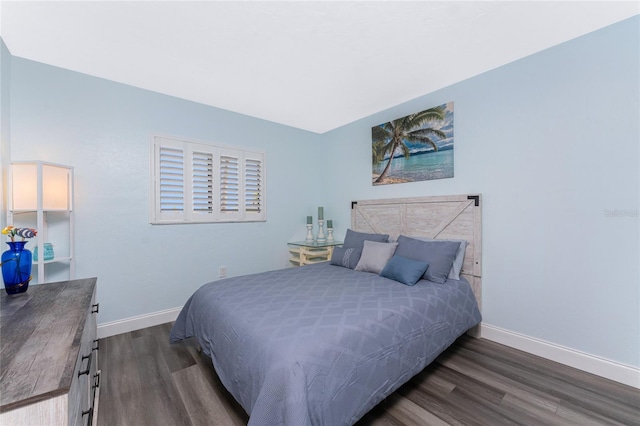 bedroom with dark wood-style flooring and baseboards