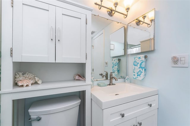 bathroom featuring toilet, visible vents, and vanity