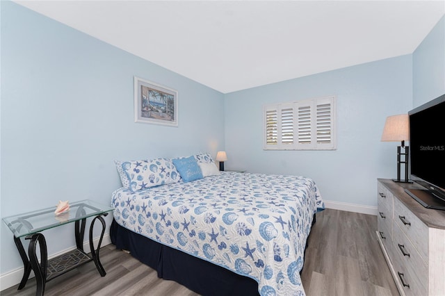 bedroom with baseboards and wood finished floors