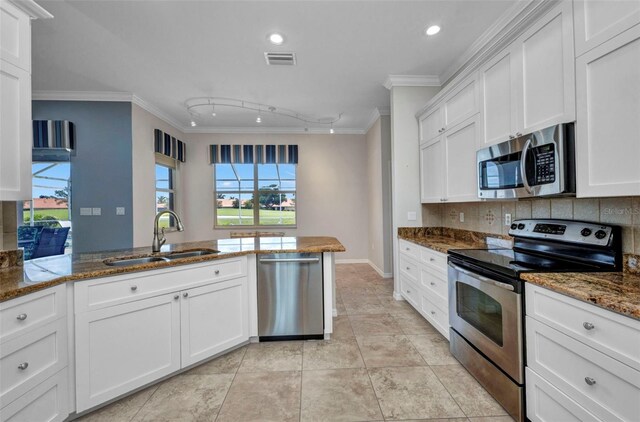12951 SW Kingsway Cir, Lake Suzy, FL 34269 - kitchen featuring appliances with stainless steel finishes, a sink, ornamental molding, backsplash, and white cabinets
