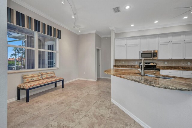 12951 SW Kingsway Cir, Lake Suzy, FL 34269 - kitchen featuring appliances with stainless steel finishes, dark stone counters, tasteful backsplash, crown molding, and white cabinets