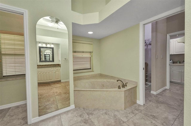 12951 SW Kingsway Cir, Lake Suzy, FL 34269 - bathroom with ceiling fan, a bath, vanity, baseboards, and tile patterned floors