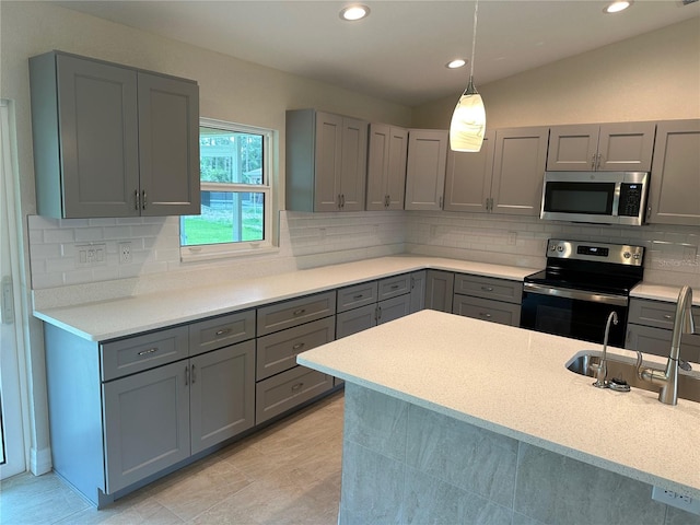 kitchen with light countertops, gray cabinets, stainless steel appliances, and a sink