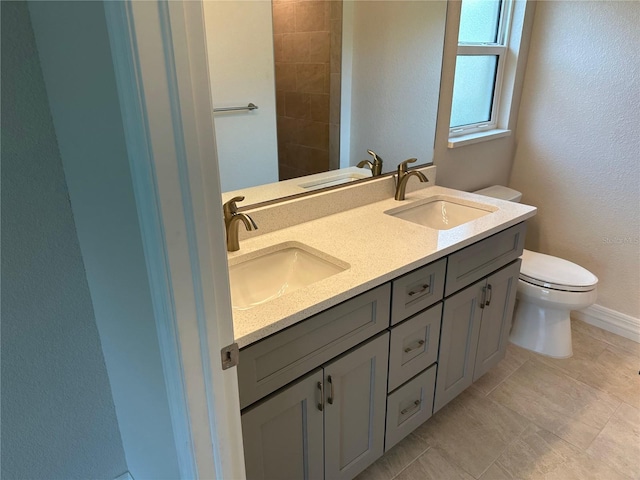 full bathroom with a sink, double vanity, and toilet