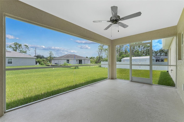 unfurnished sunroom featuring a ceiling fan