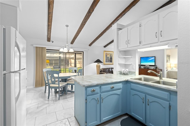 5301 Linksman Pl, North Port, FL 34287 - kitchen with freestanding refrigerator, a sink, a peninsula, blue cabinets, and white cabinets