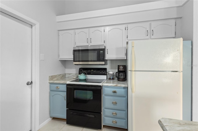5301 Linksman Pl, North Port, FL 34287 - kitchen with freestanding refrigerator, electric range, stainless steel microwave, light countertops, and blue cabinets