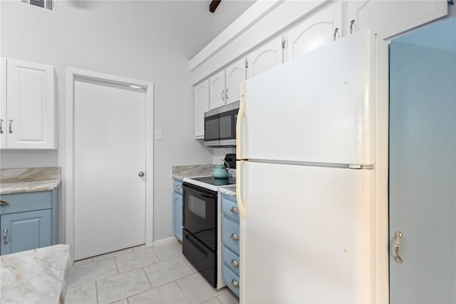 5301 Linksman Pl, North Port, FL 34287 - kitchen with stainless steel microwave, freestanding refrigerator, electric range, light countertops, and white cabinetry