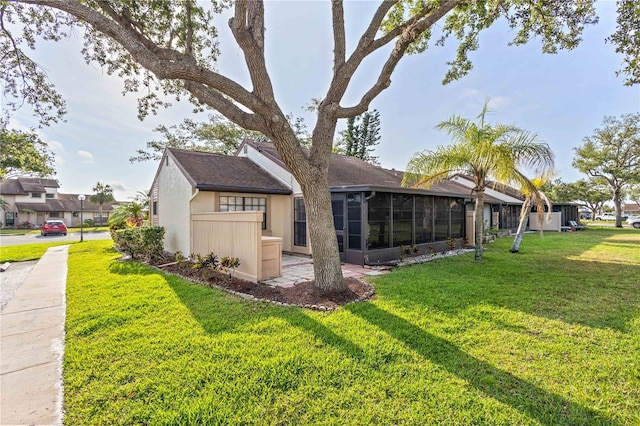5301 Linksman Pl, North Port, FL 34287 - rear view of property with a yard, a sunroom, and stucco siding