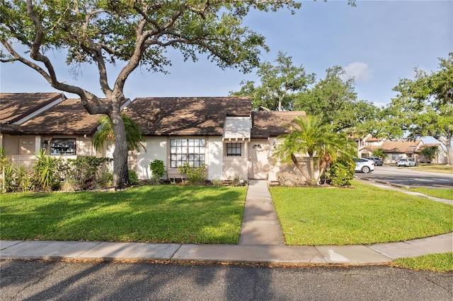 5301 Linksman Pl, North Port, FL 34287 - tudor-style house featuring a front lawn, stucco siding, and a shingled roof